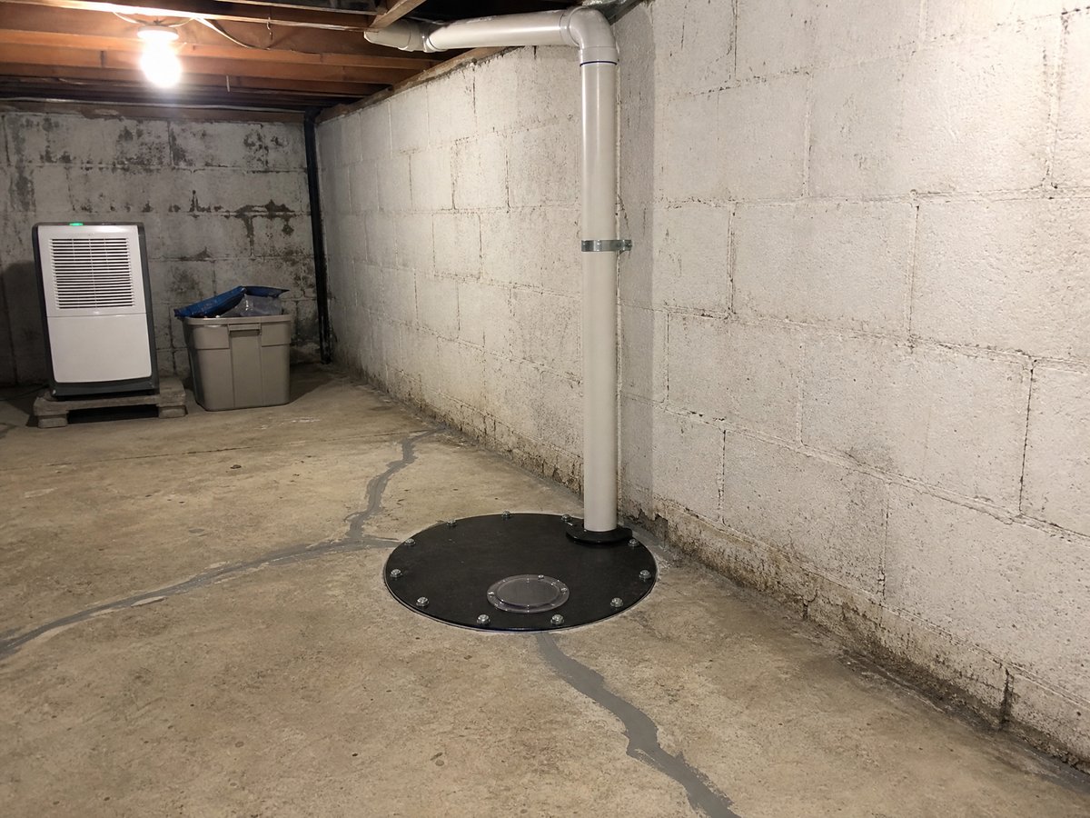 Sealed sump lid and radon mitigation pipe installed in a Sioux Falls basement